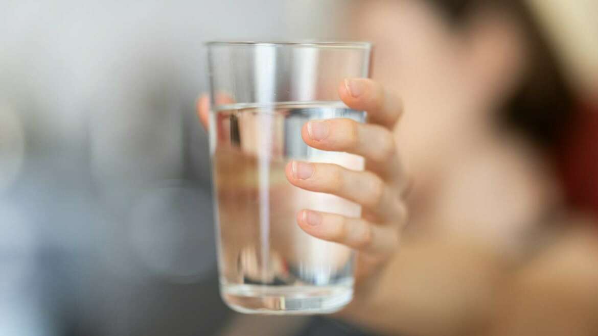 person holding clear drinking glass